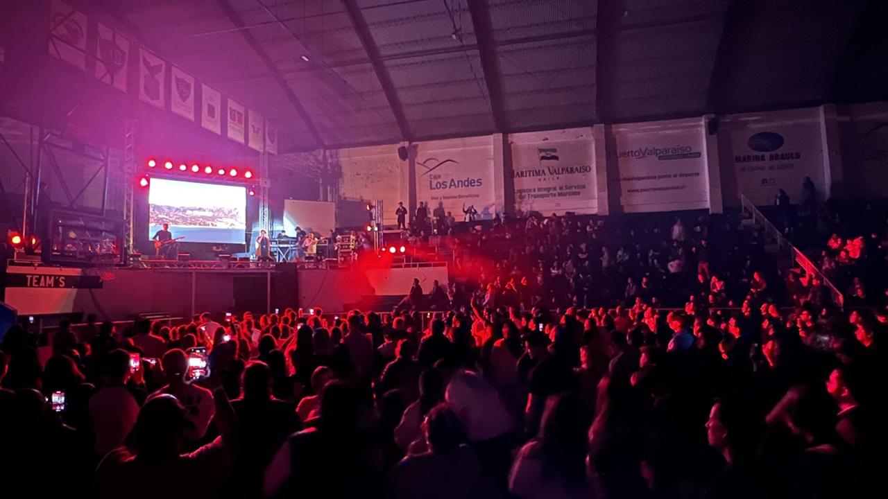 Concierto con público, escenario iluminado y pantalla