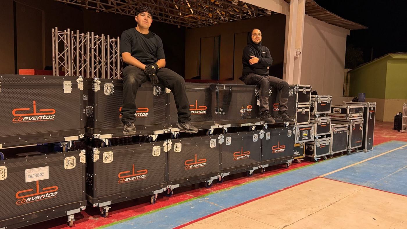 Equipo técnico de CB Eventos sentado sobre los cases de equipos